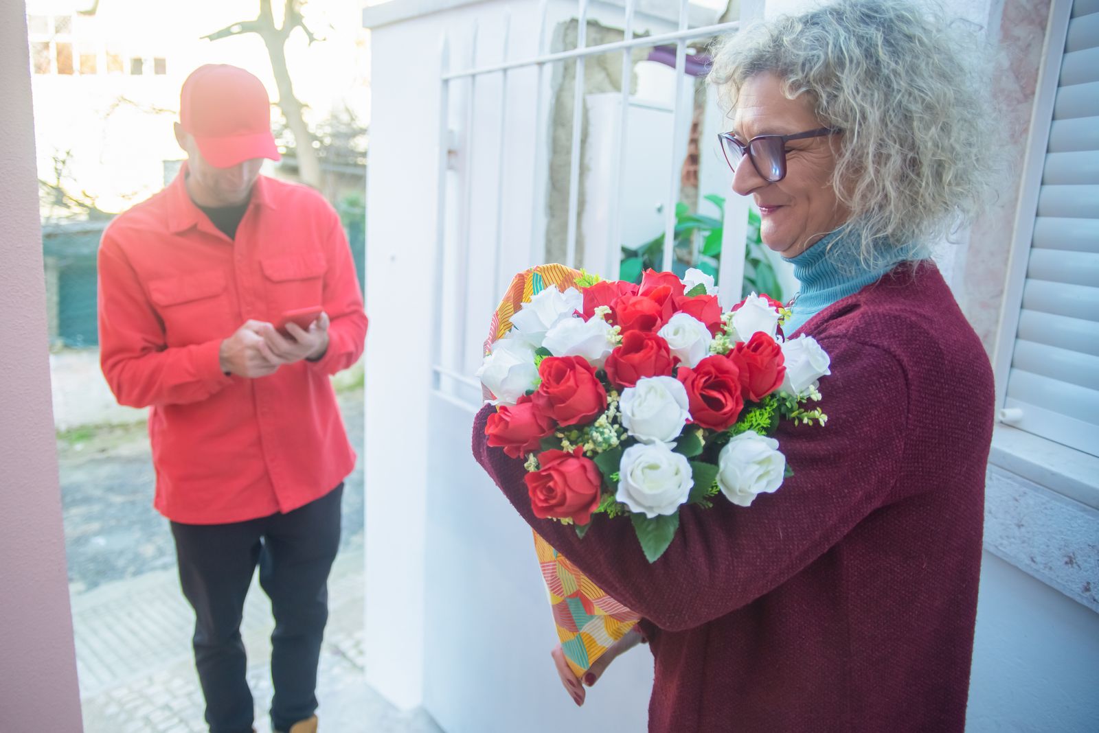 A bouquet being handed over at a front door